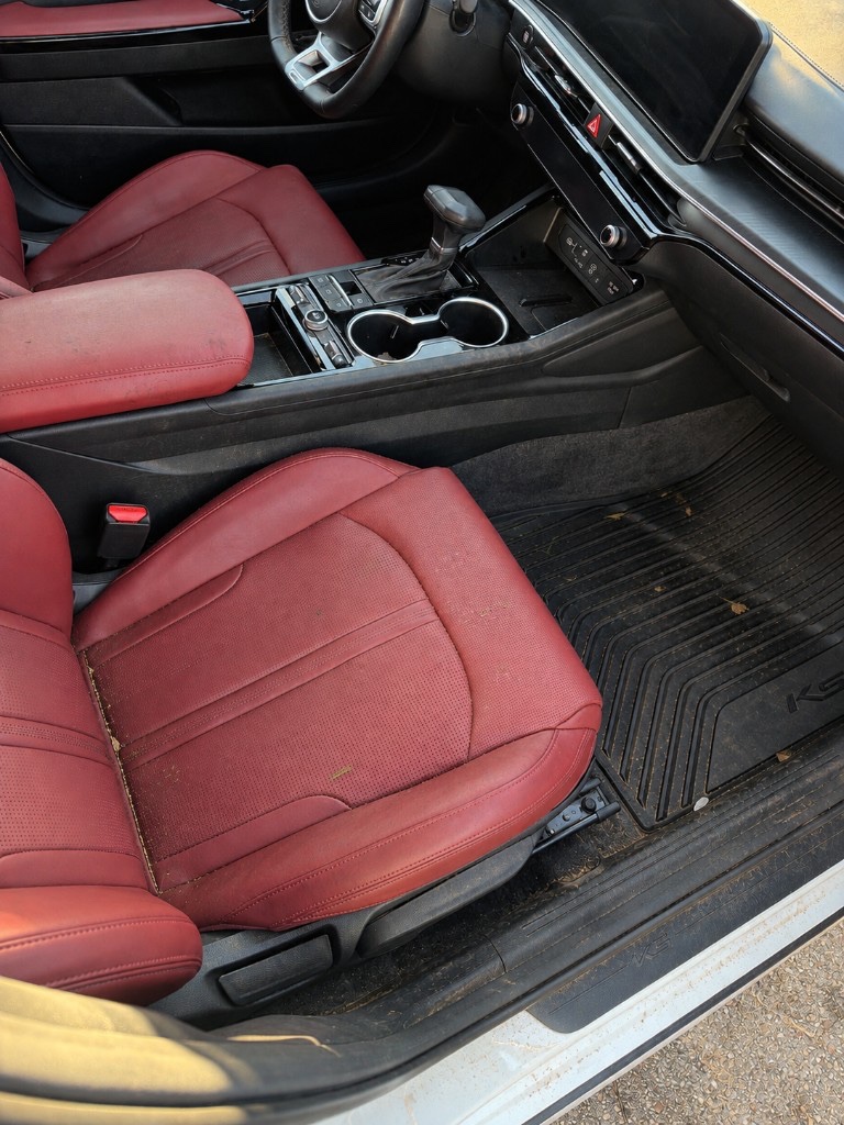Kia K5 interior before detailing — dirty seats, console, and floor mats