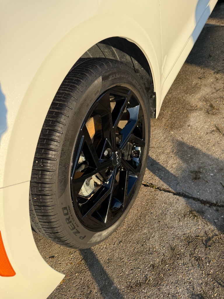 Clean Kia black alloy wheel with Pirelli tire after detailing